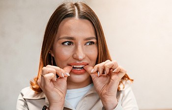 Patient putting on clear aligner in treatment room