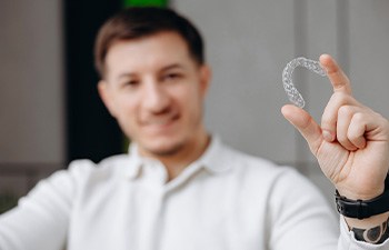 Man holding his Invisalign aligner