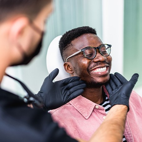Dentist looking at patient's smile in treatment chair