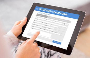 Person filling out insurance claim form on tablet