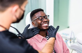 Dentist looking at patient's smile in treatment room