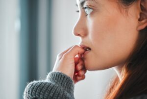 Profile view of woman biting her nails